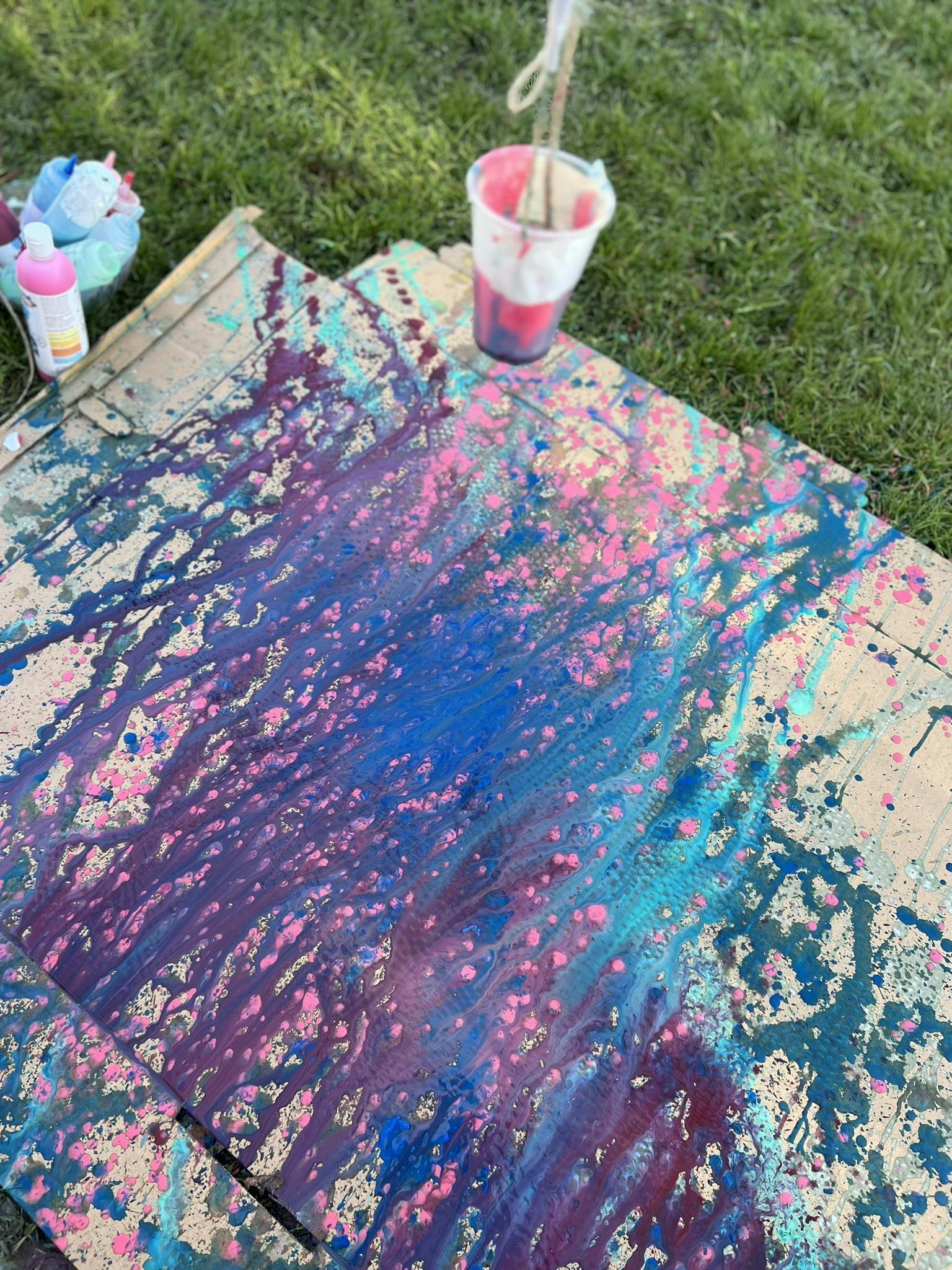 splatter paint on cardboard with shades of pink, blue, and purple