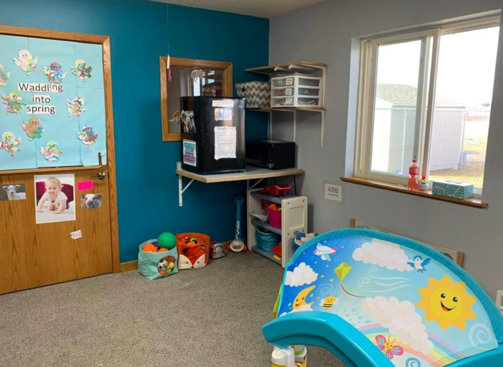 Playroom with a door, window, and children's toys