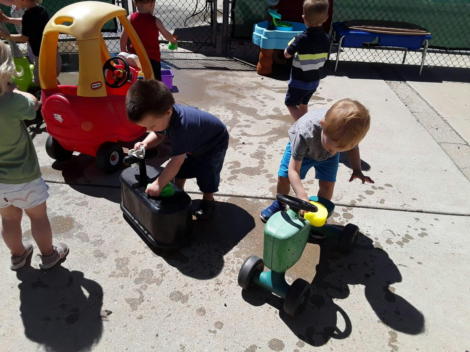 Children playing with ride-on toys outdoors