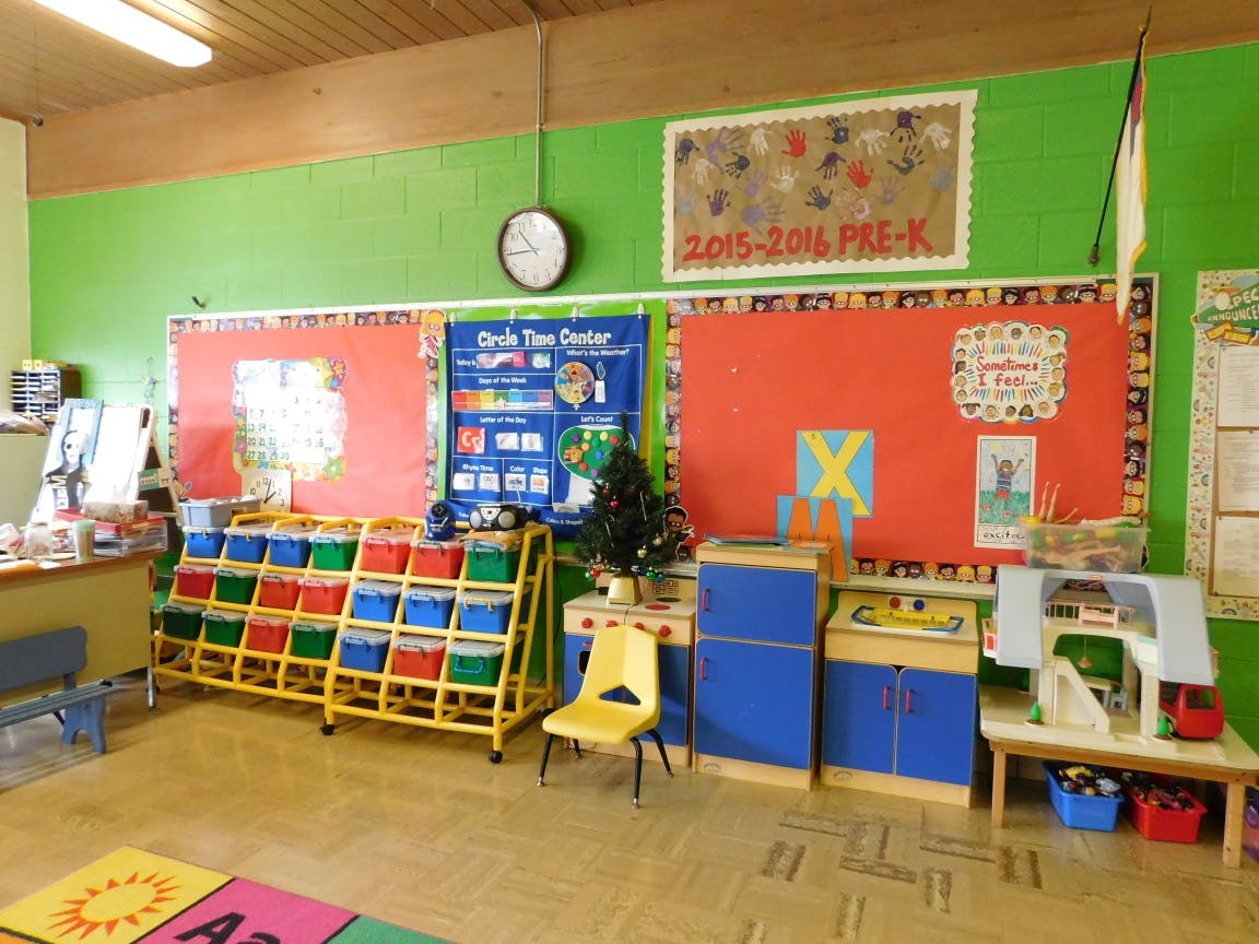 Classroom with colorful storage bins, bulletin boards, and play furniture