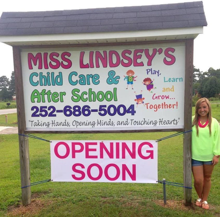 Sign for Miss Lindsey's Child Care & After School with a person standing next to it