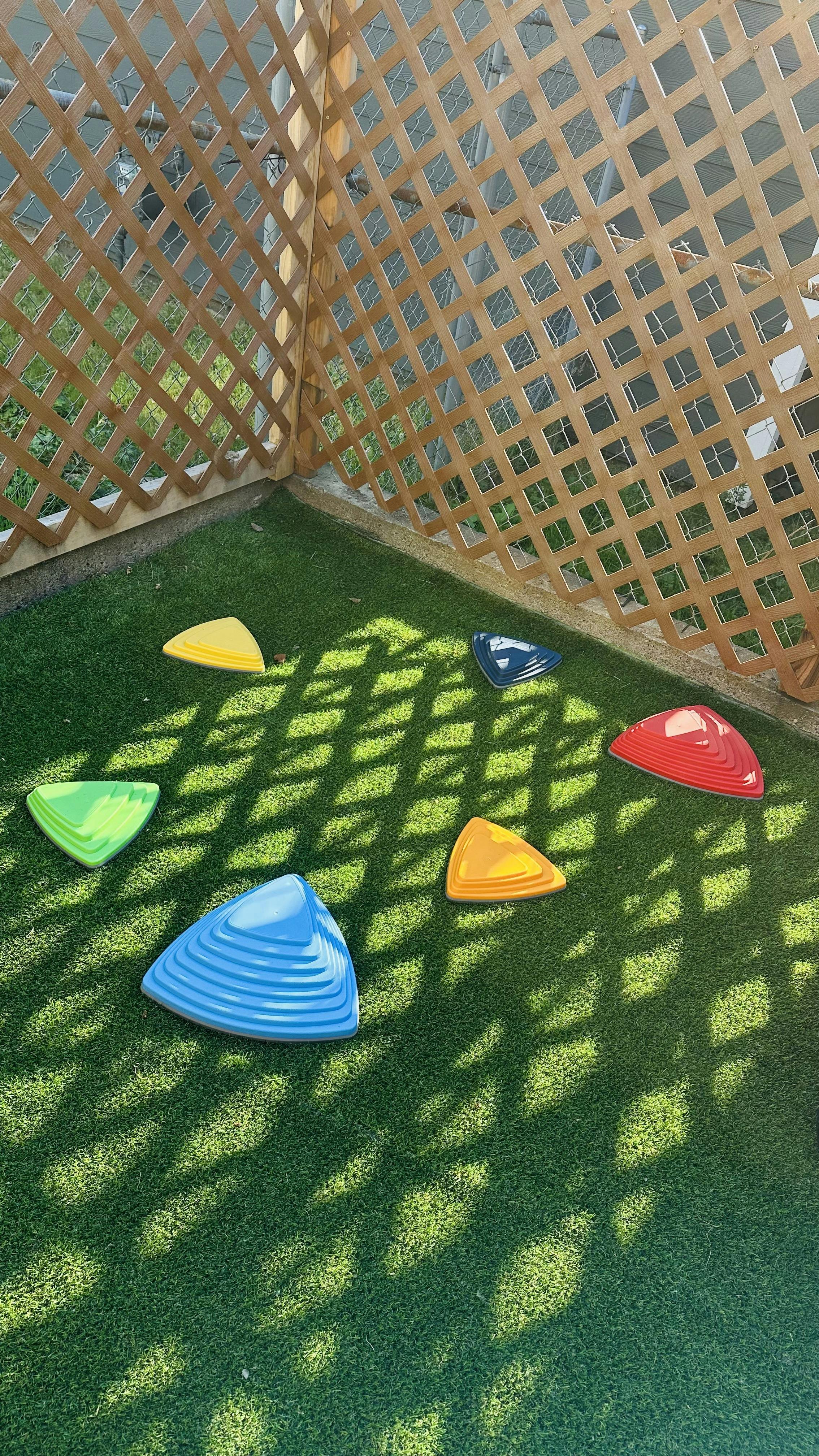Colorful triangular stepping stones on artificial grass