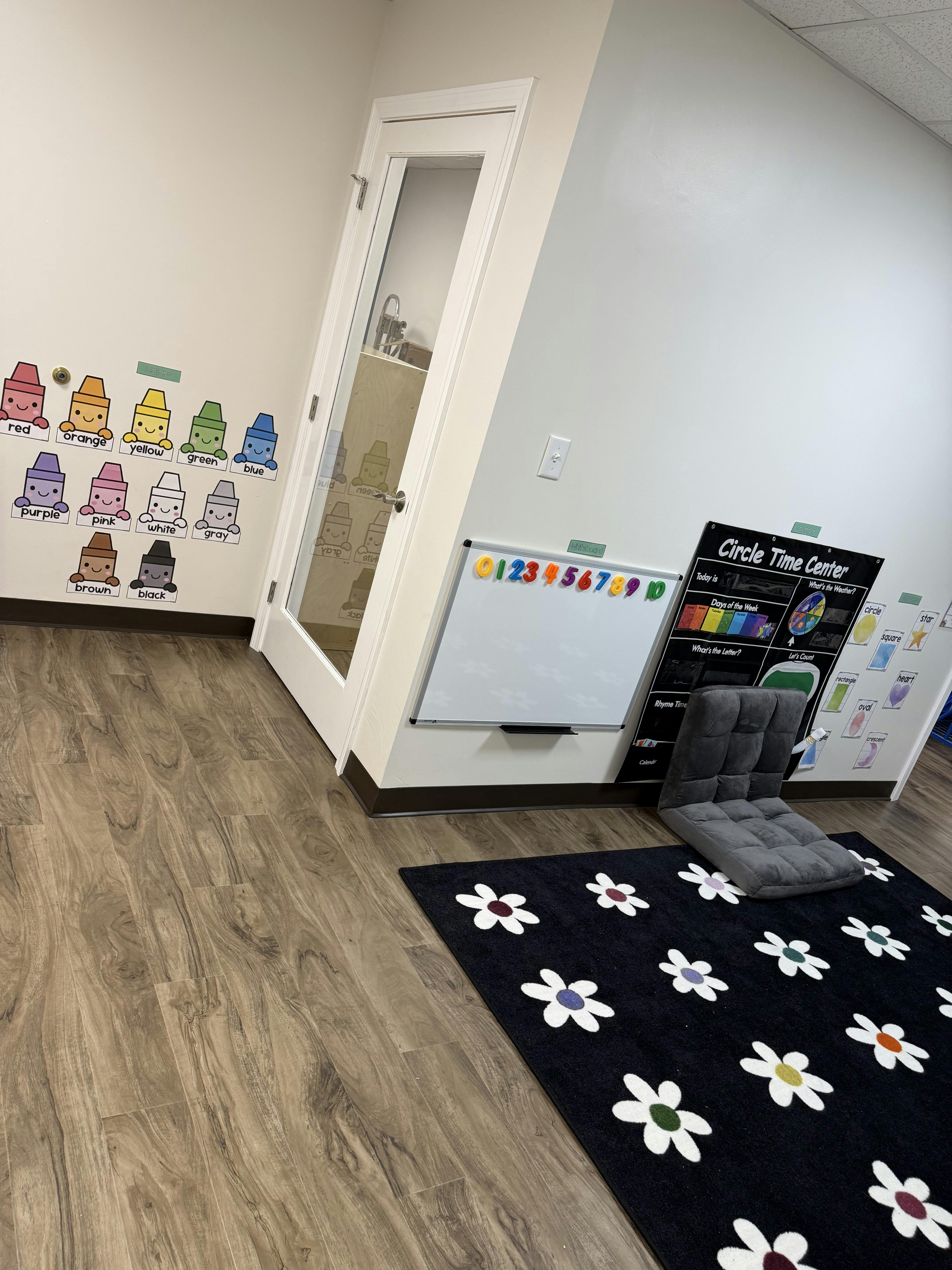 Classroom with a whiteboard, a "Circle Time Center" sign, and a black rug with flowers