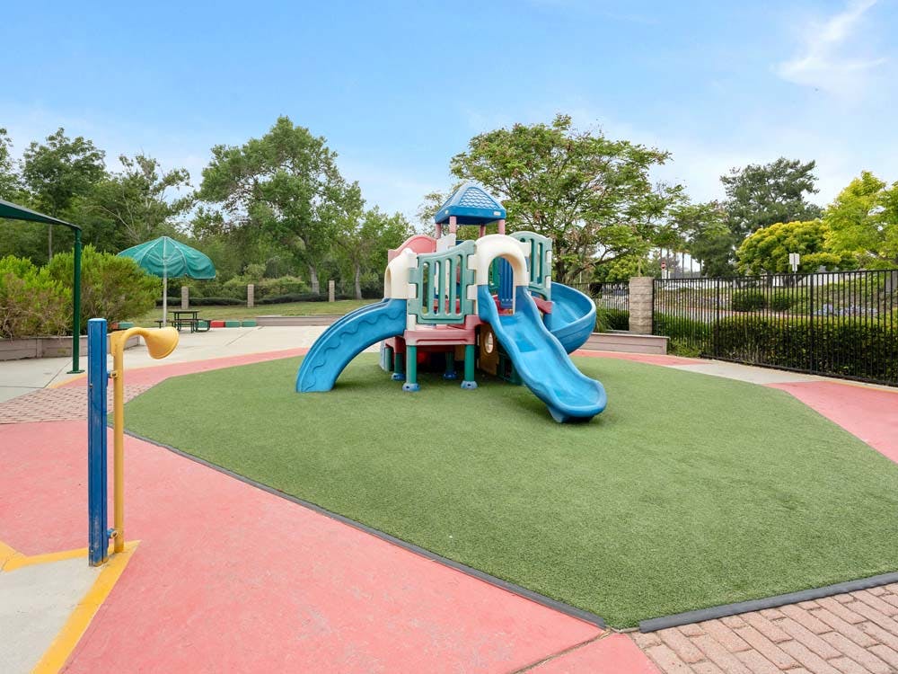 Colorful playground structure with slides on artificial turf