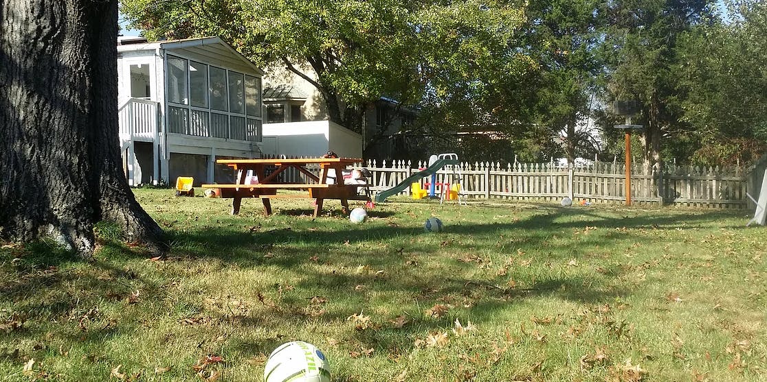 Backyard with picnic table, slide, and white picket fence