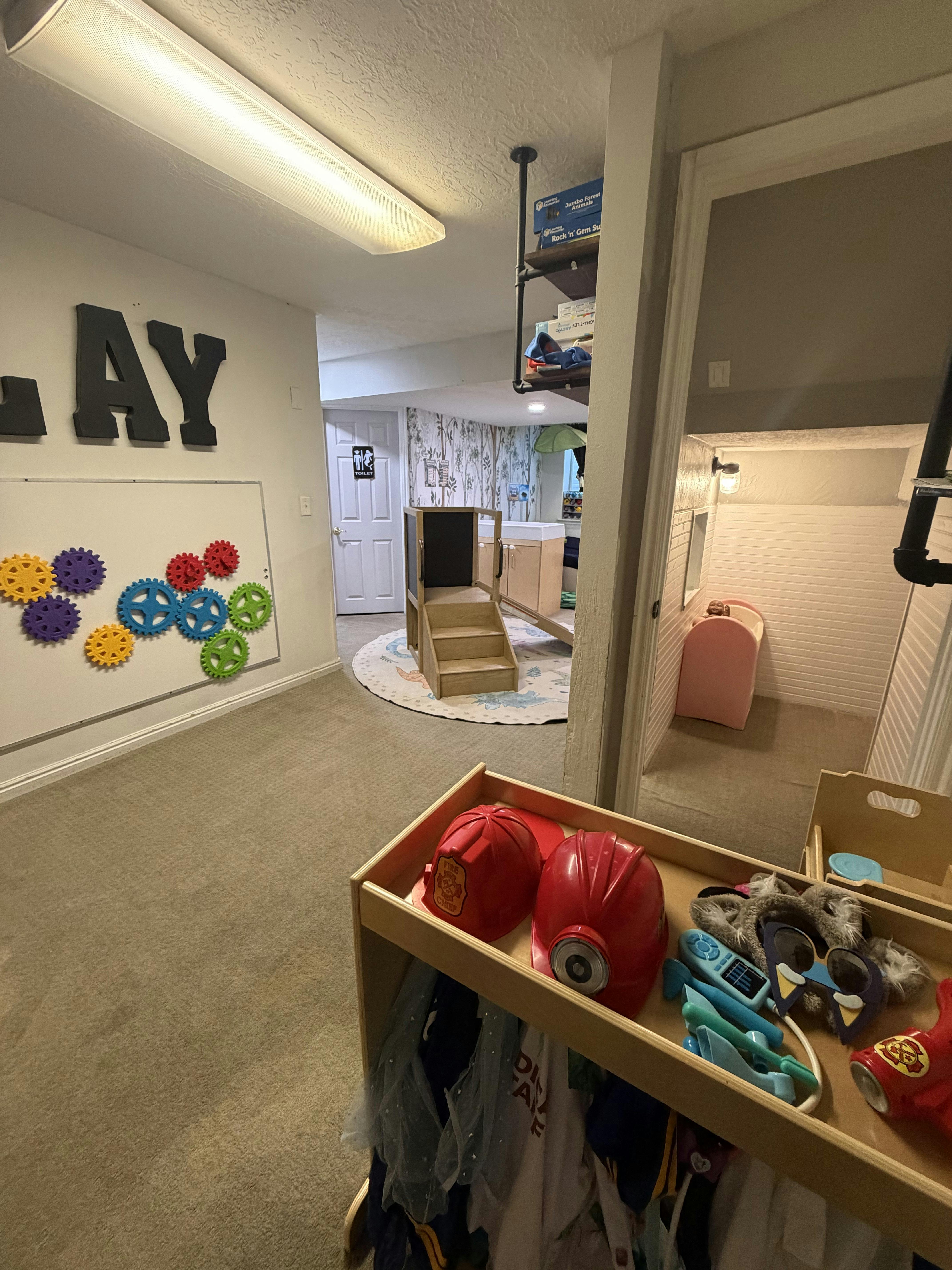 Playroom with wall-mounted gears and a small costume rack in the foreground