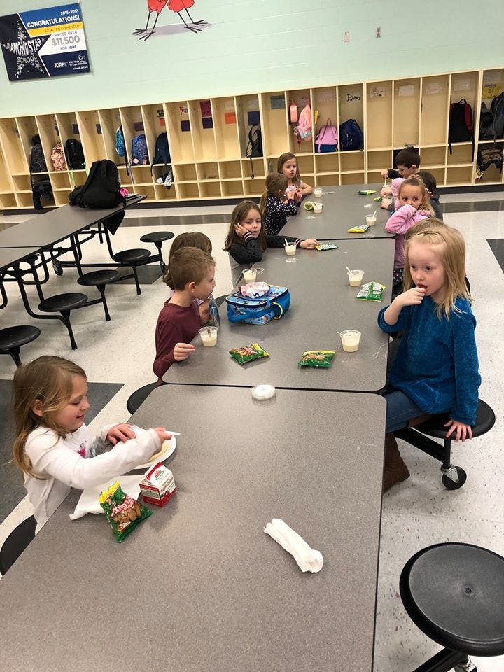 Children sitting at tables in a classroom