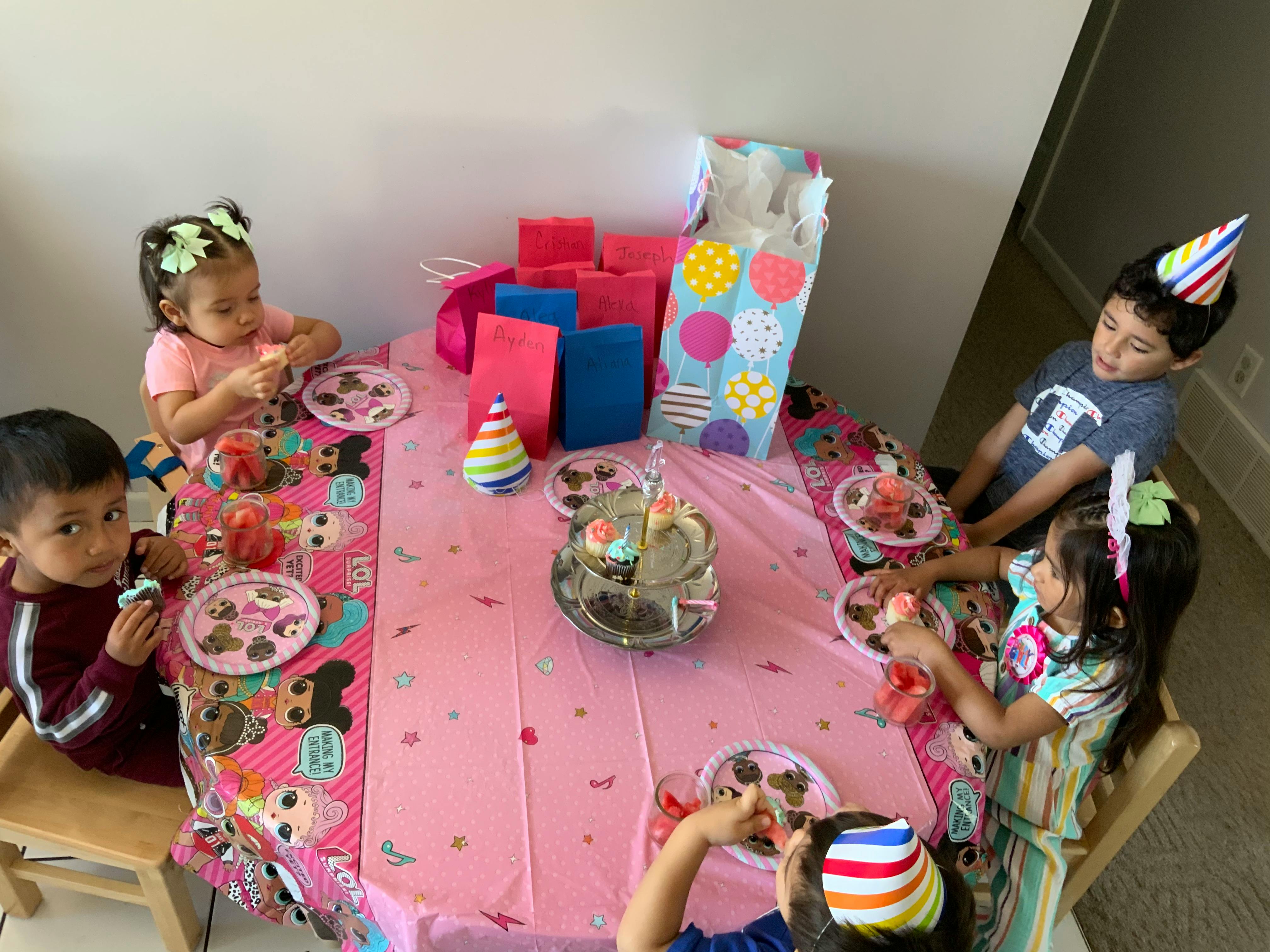 Children eating cupcakes at a table with party decorations