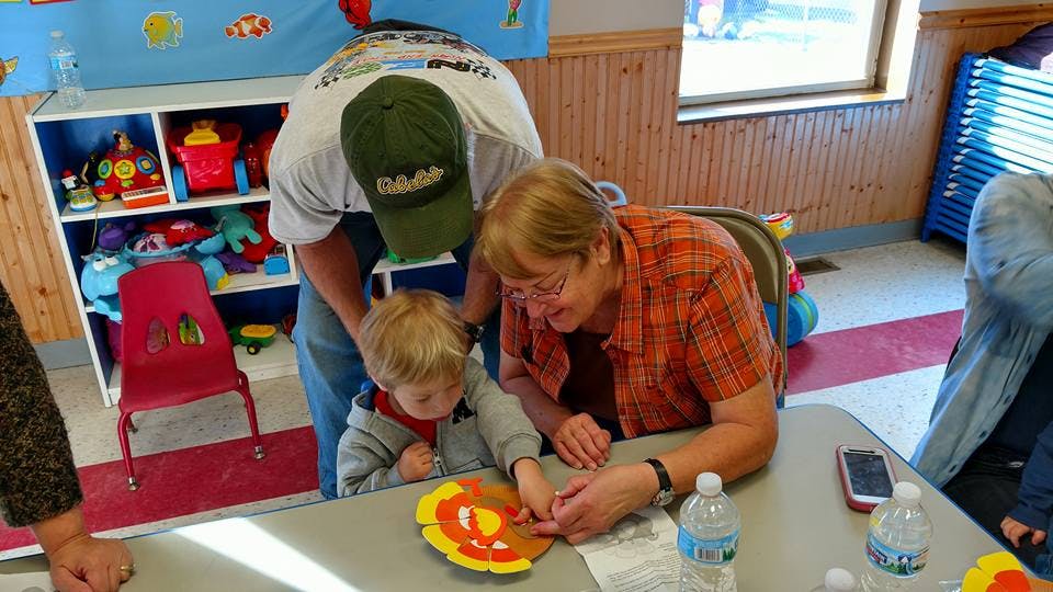 Adults and child doing crafts at a table
