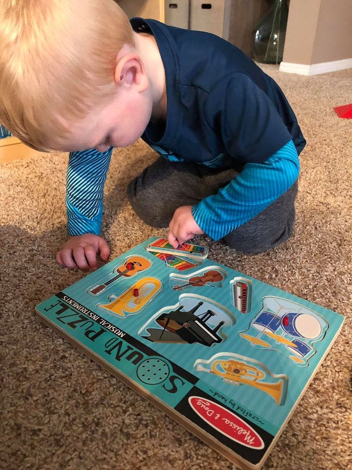 Child playing with a musical instrument sound puzzle