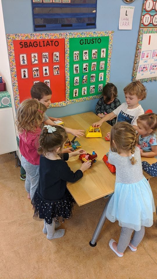 Children playing with toys at a table in a classroom
