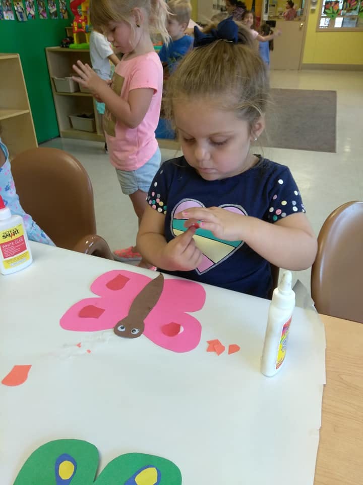 Child making a paper butterfly craft