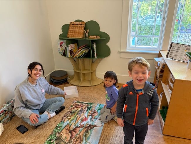 Adult and two children on the floor with a puzzle