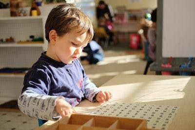 Child working with a learning board in a classroom