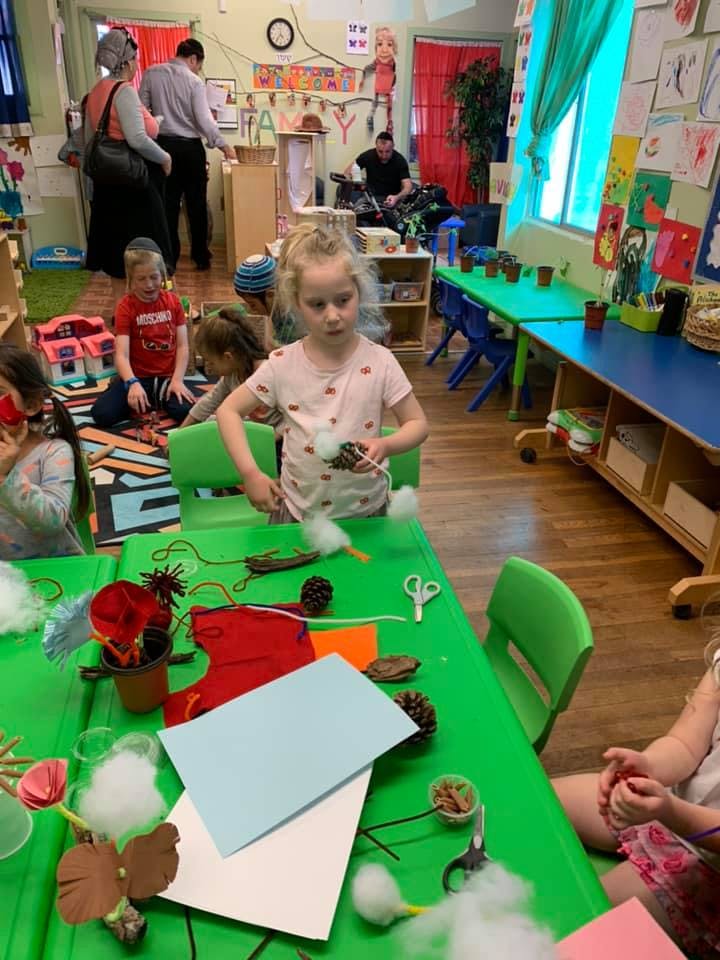 Child making crafts at a table in a classroom