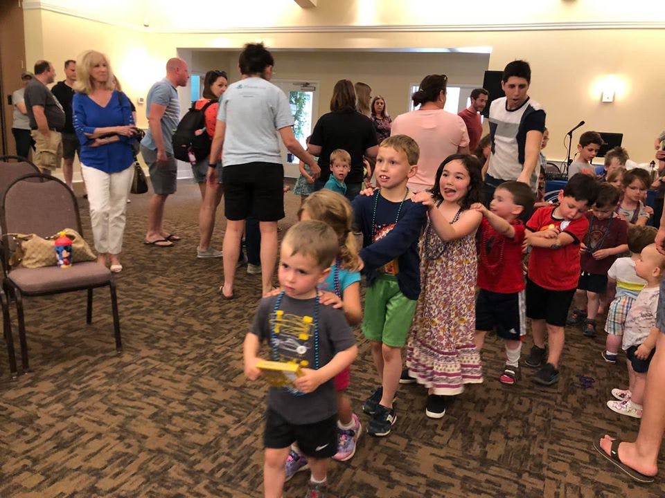 Adults and children standing in a room