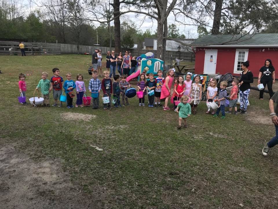 Group of children holding baskets in a grassy area