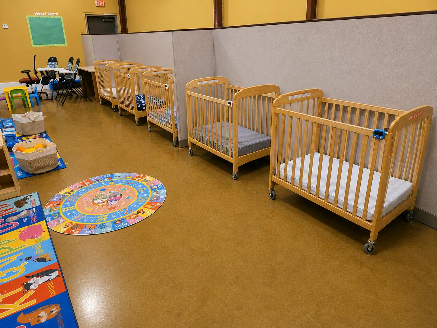 Wooden cribs lined up in a child care classroom