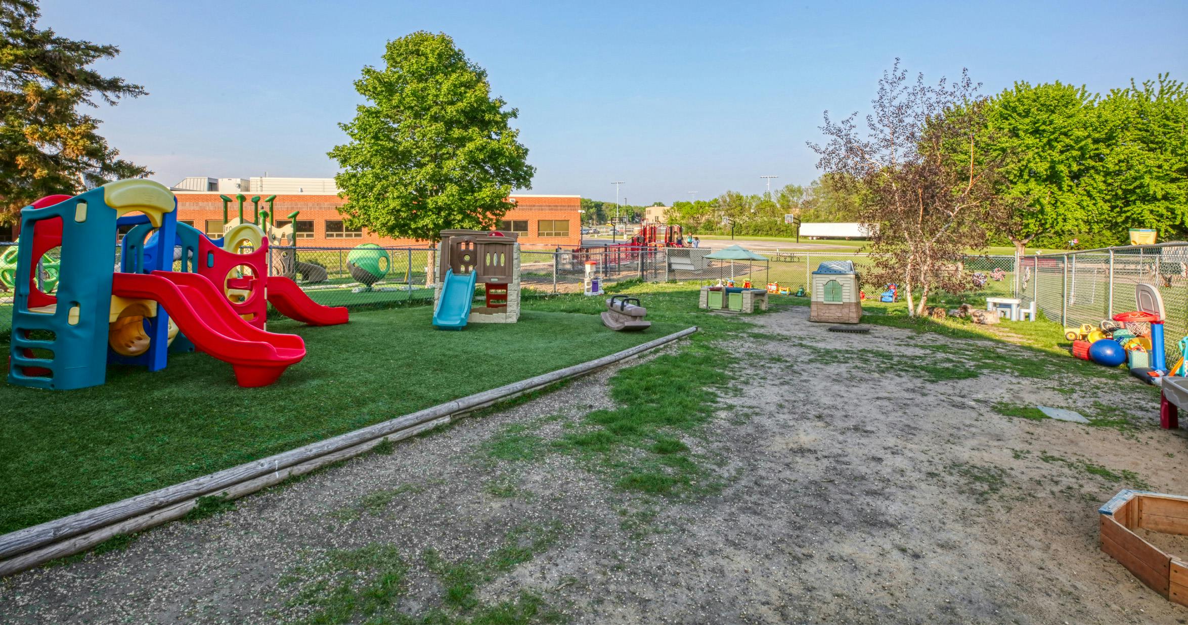 Outdoor playground with red slides and various play structures