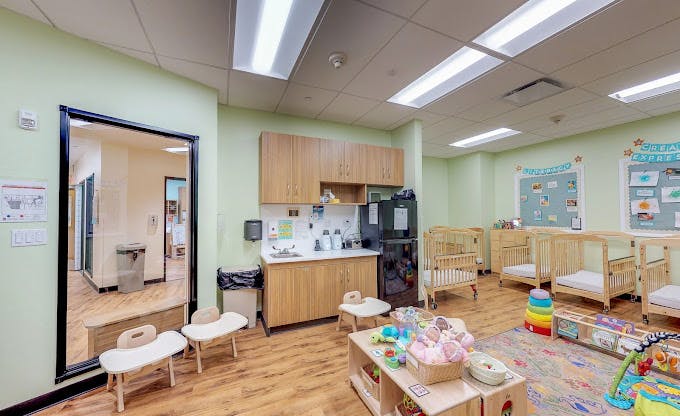 Classroom for children with cribs, play area, and kitchen counter