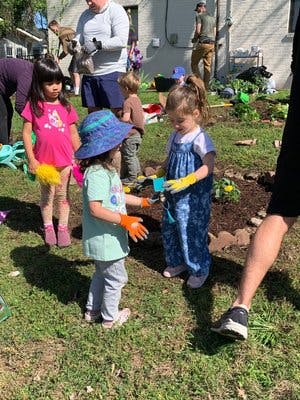 Children wearing gloves in a garden