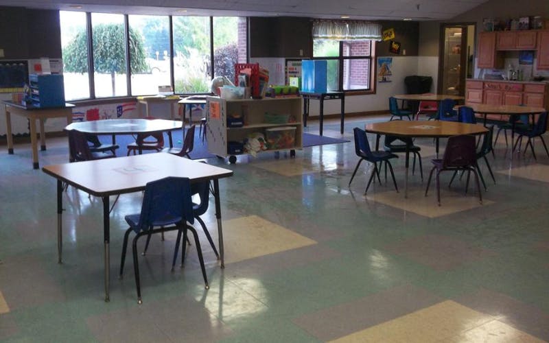 Empty classroom with small tables and chairs