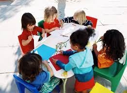 Children sitting around a table doing crafts