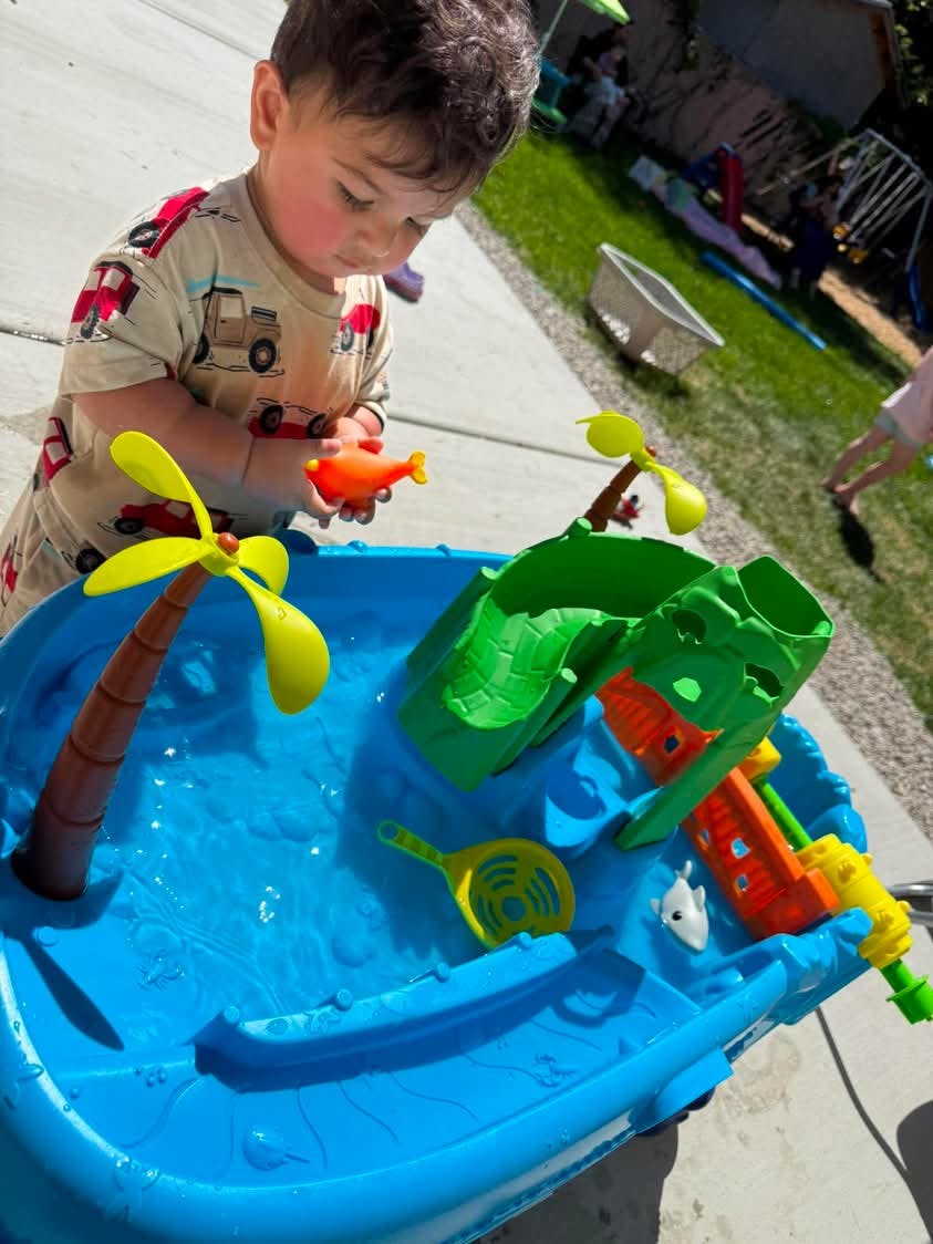 Child playing with a water table outside