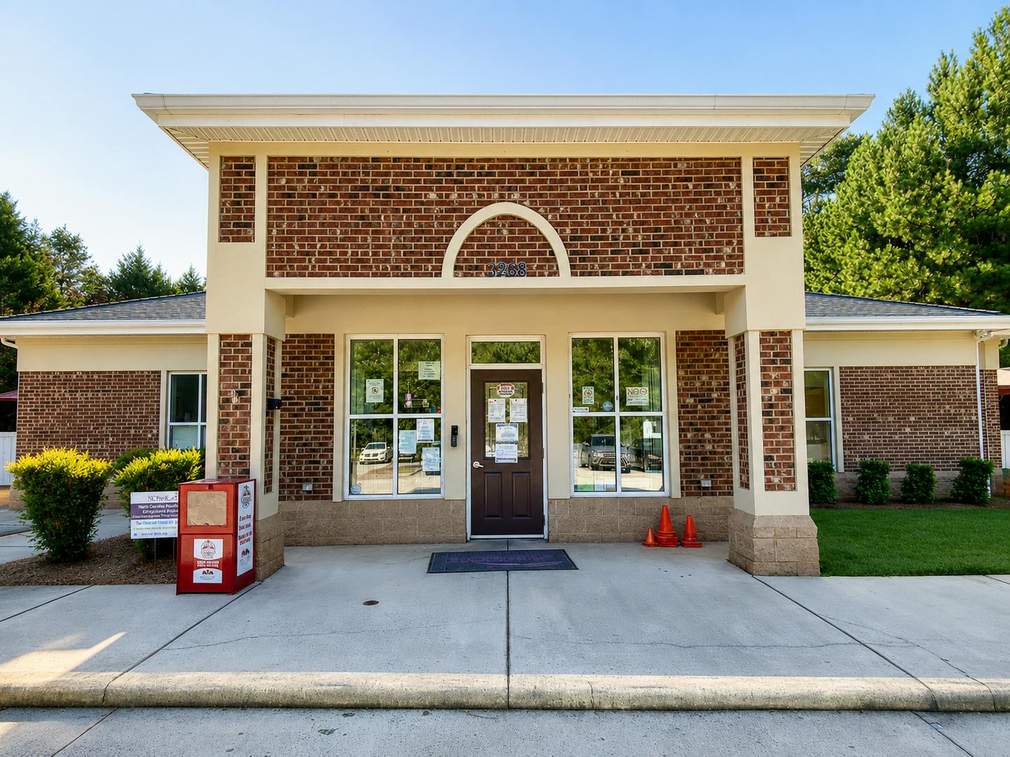 Brick commercial building entrance with a centered brown door and number 3268