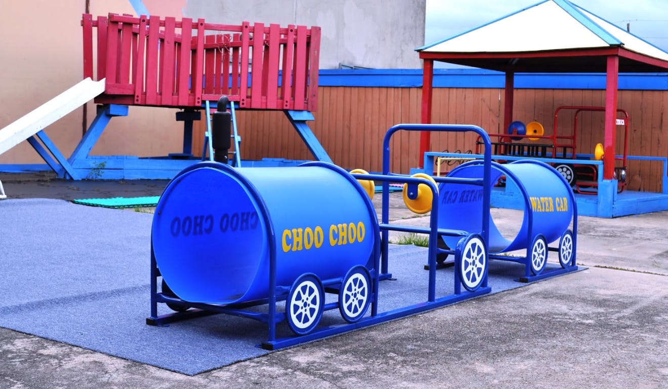 Blue train playground equipment with "CHOO CHOO" written on it