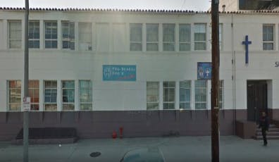 Building with multiple windows and a blue cross on the facade