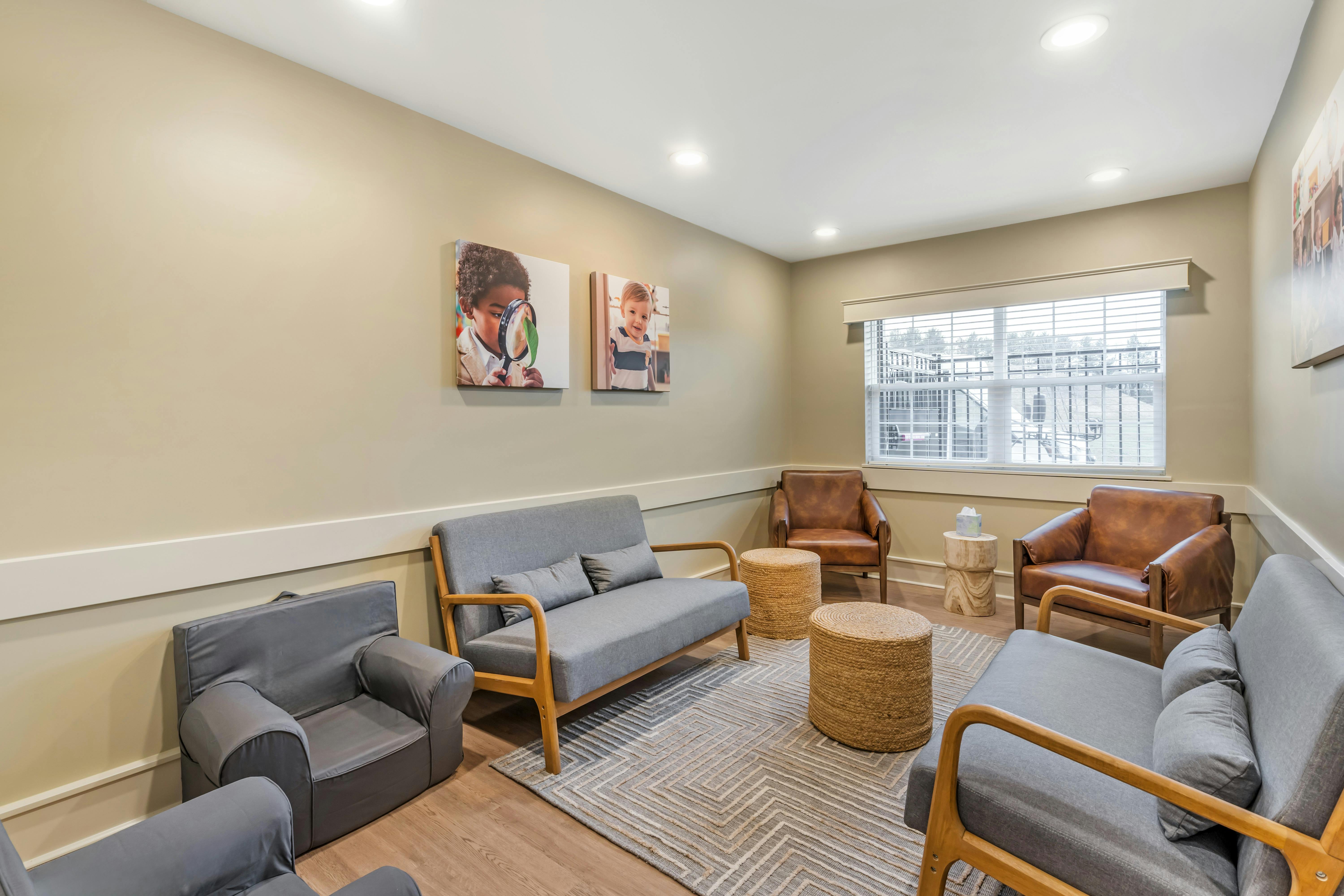 Waiting room with grey sofas and brown leather chairs