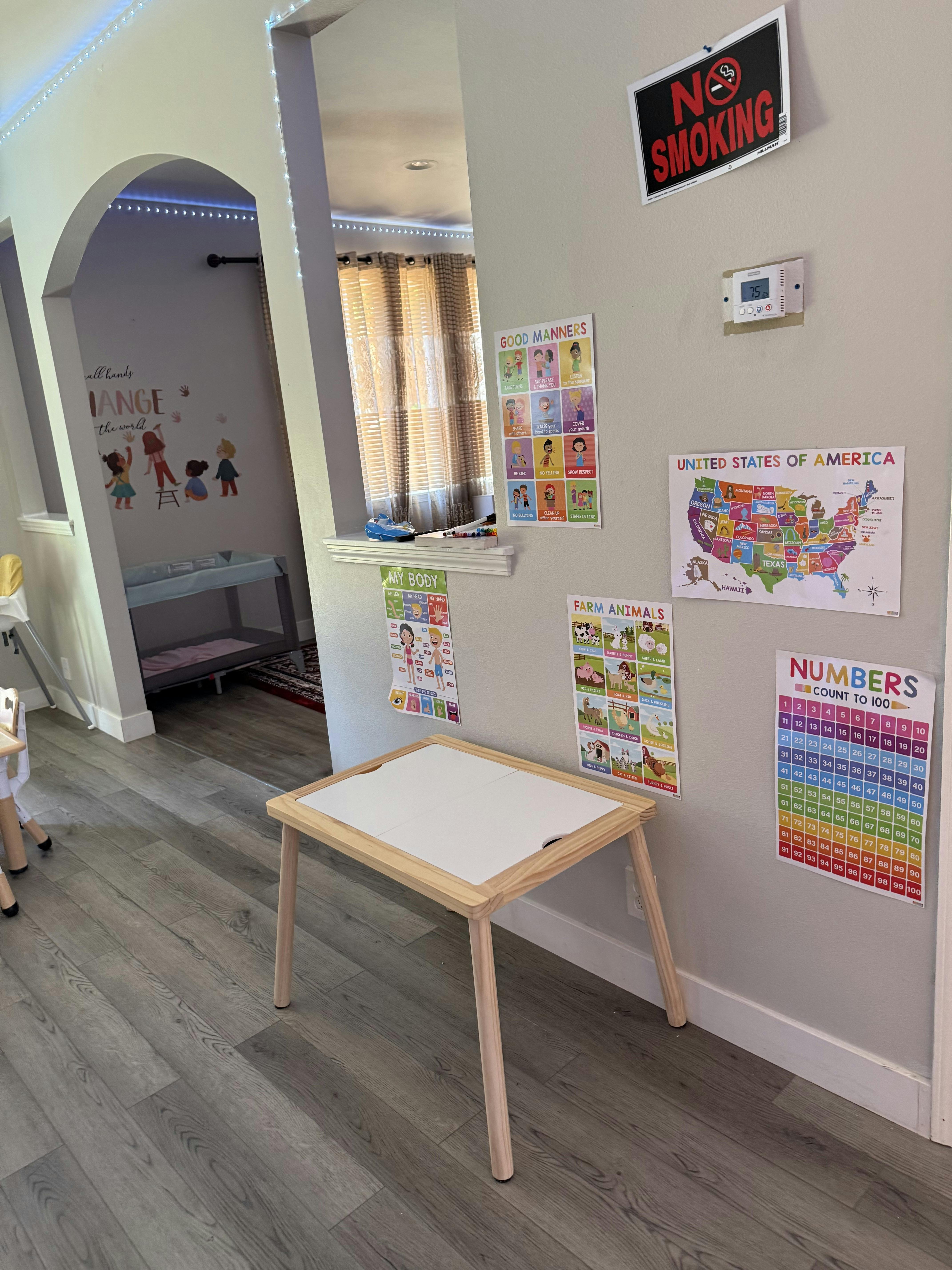 Small wooden table in a playroom with educational wall posters