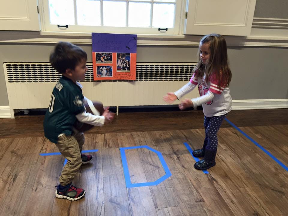 Two children playing with a football indoors