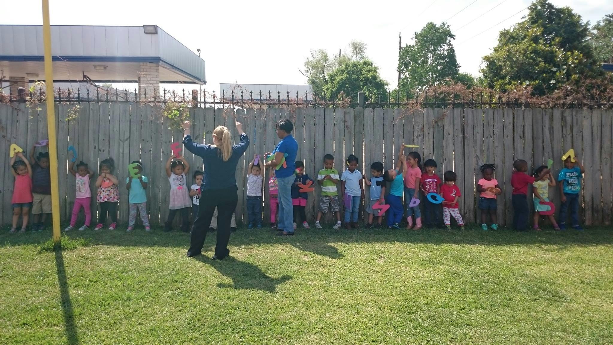 Adult and children standing in a line outdoors