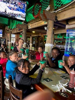 Children and an adult sitting at a table with drinks
