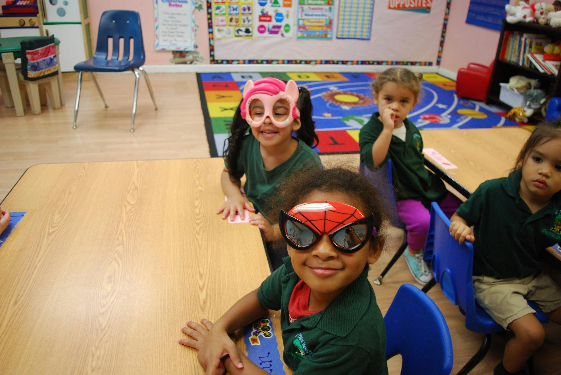 Children in a classroom wearing masks and sunglasses