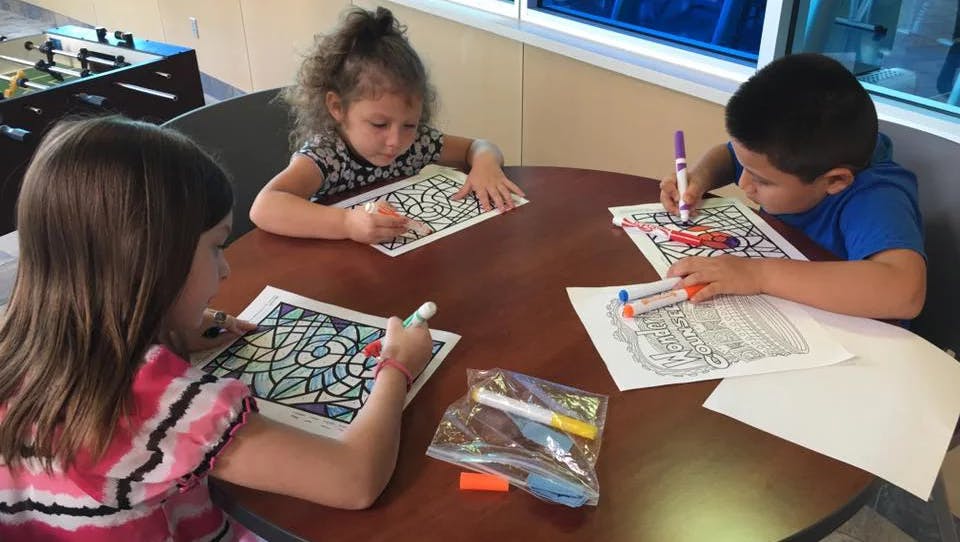 Three children coloring at a table