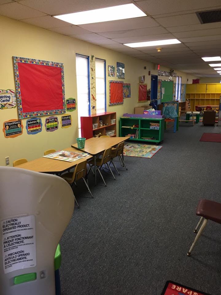 Classroom with small tables and chairs, shelves, and wall decorations