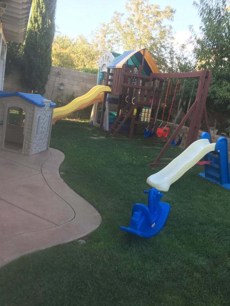 Backyard playground with swings, slides, and a playhouse