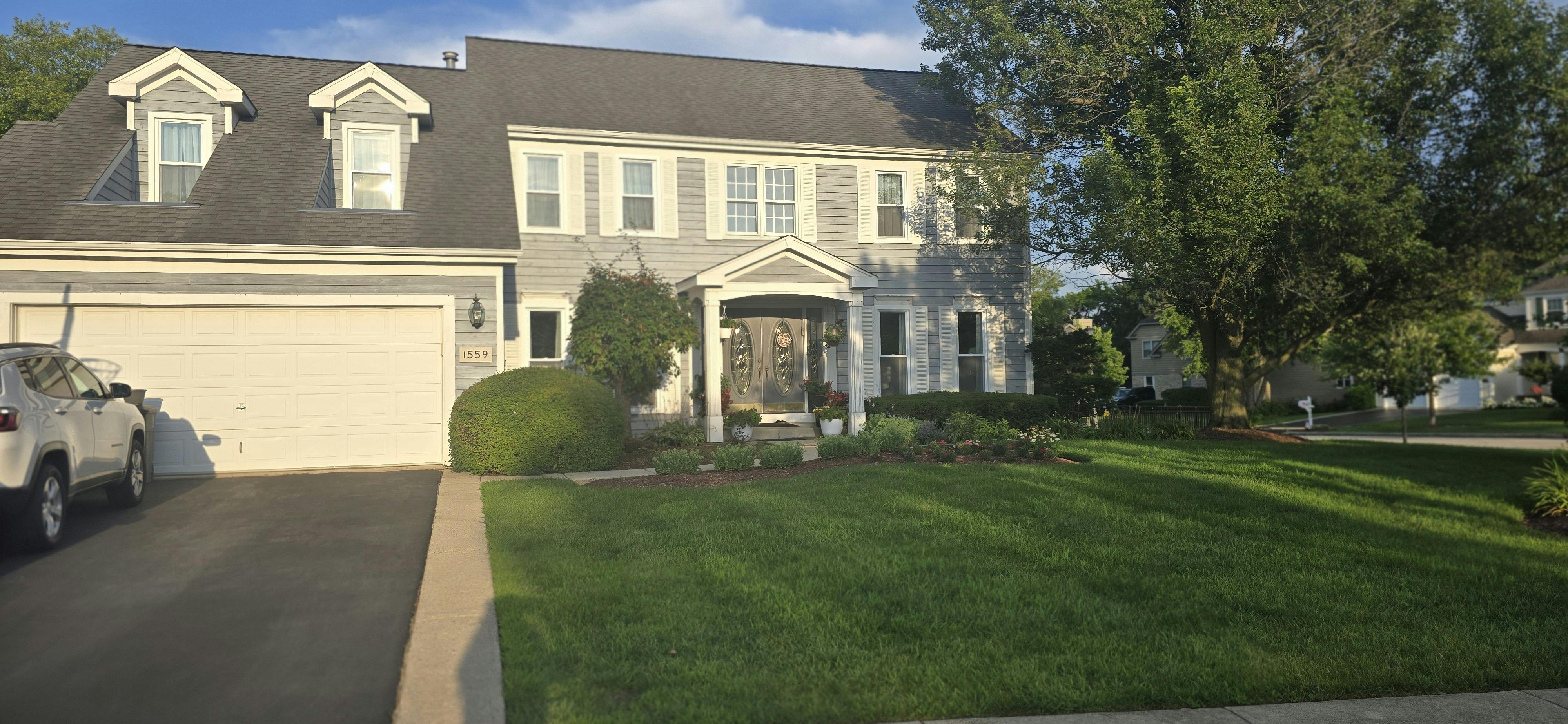 Large house with a two-car garage and a green lawn