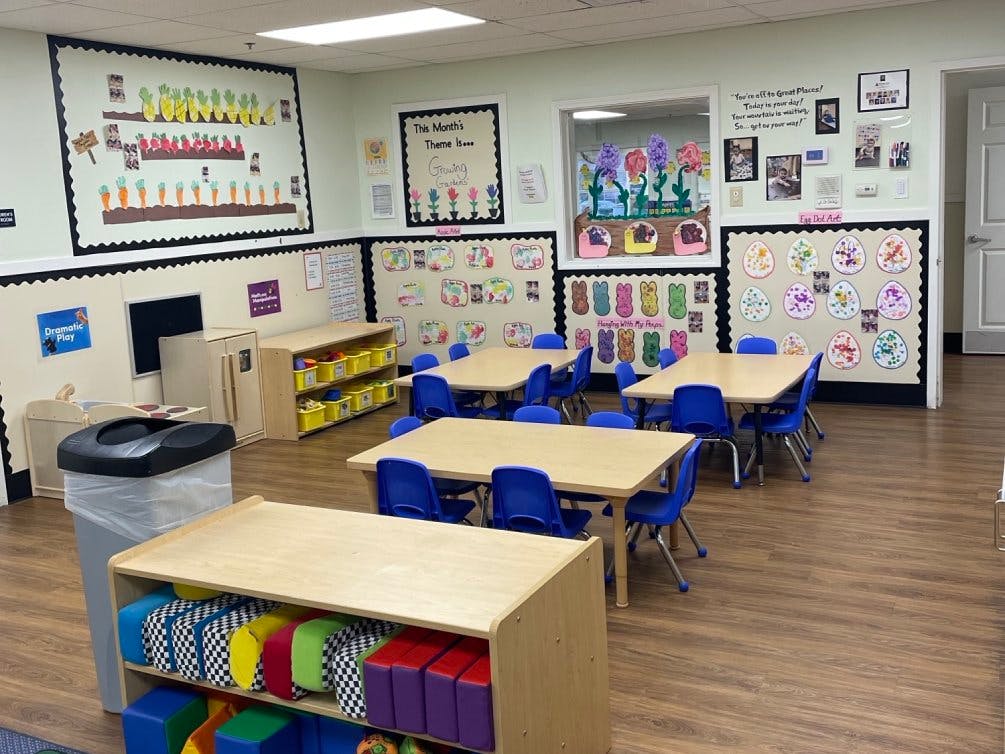 Empty classroom with small tables, chairs, and colorful decorations