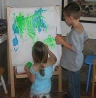 Two children painting on an easel