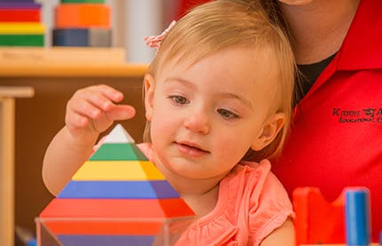 Child playing with a colorful pyramid toy