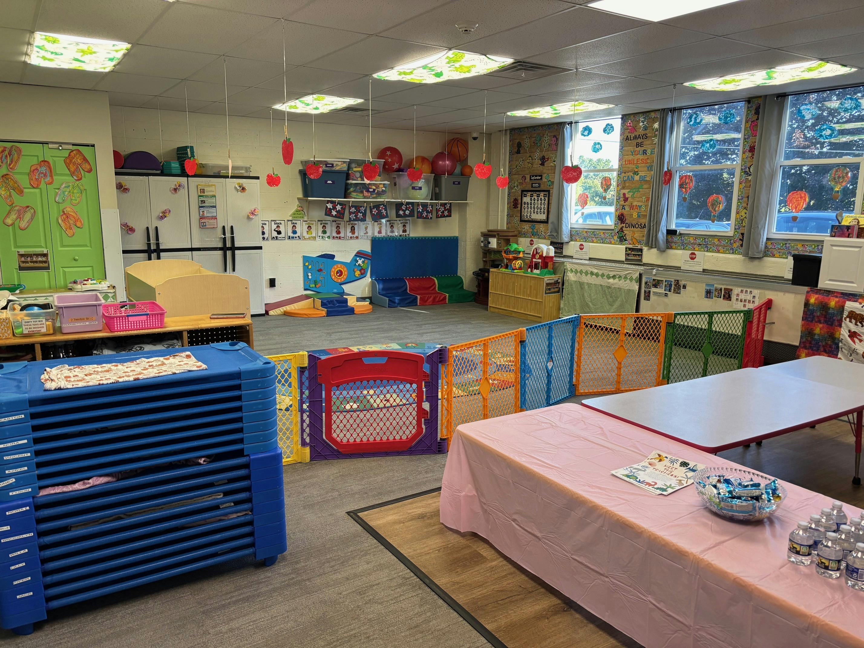 A classroom with colorful playpens and tables