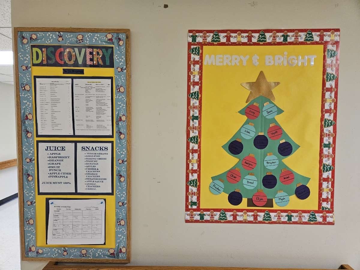 Bulletin board with "DISCOVERY" and a Christmas tree poster with "MERRY & BRIGHT"