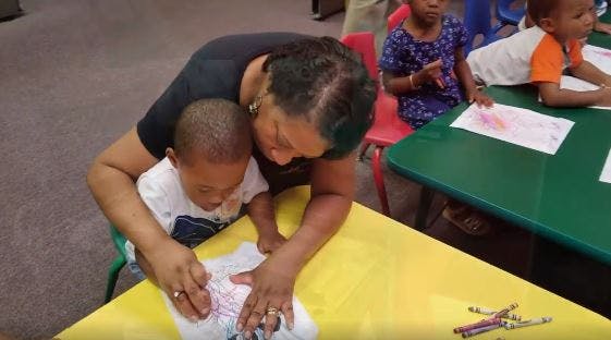Adult and child drawing together at a table