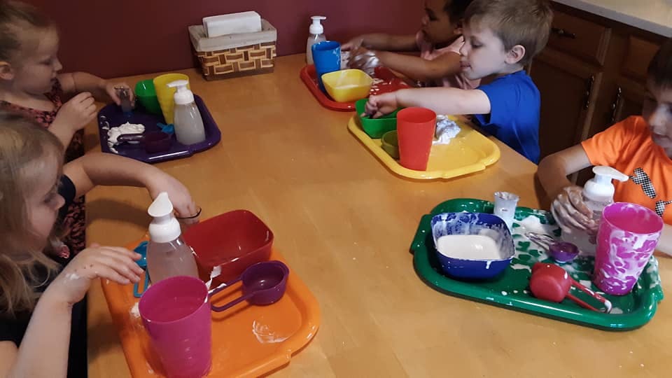 Children at a table with trays and craft supplies