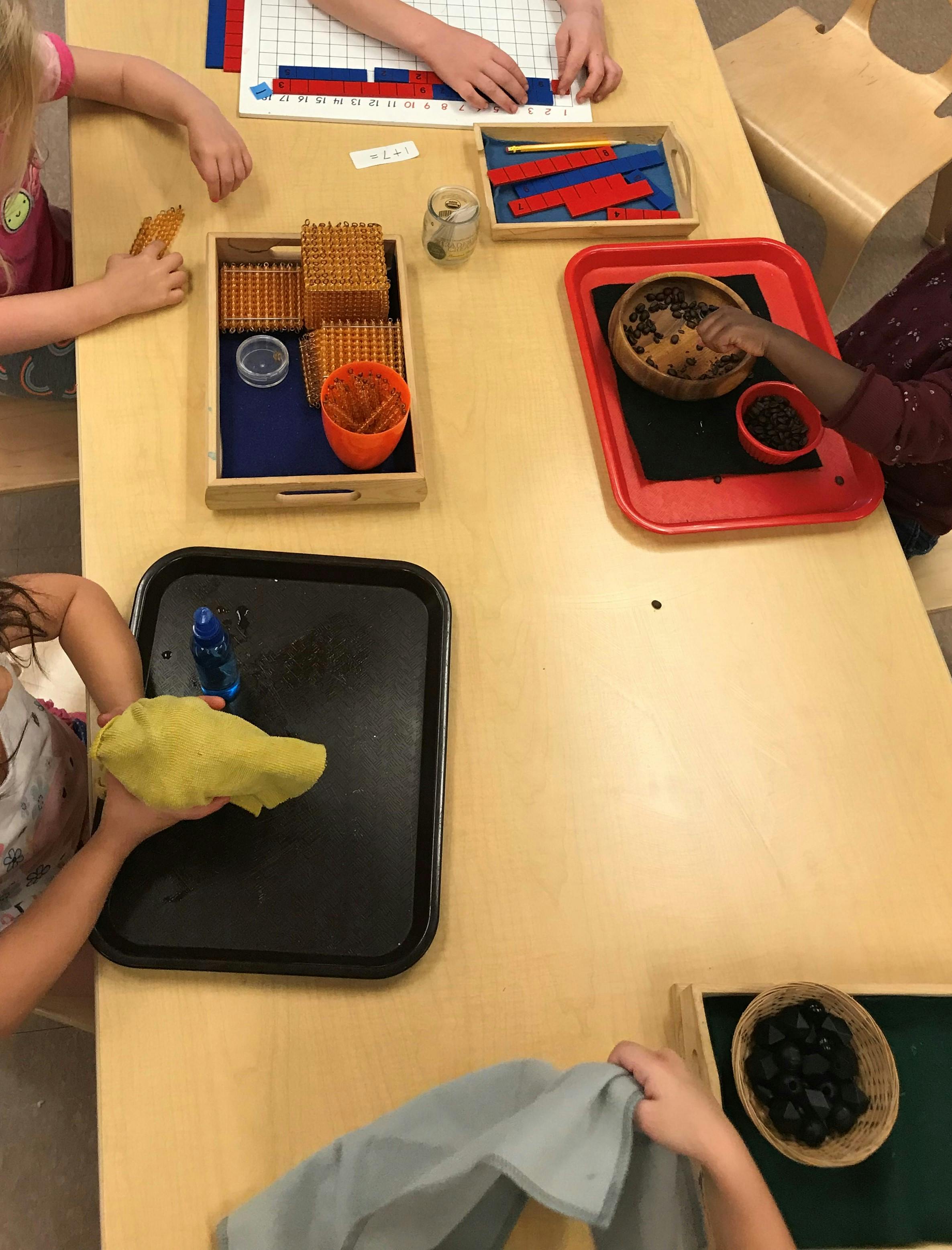 Children's hands engaged in various activities at a table