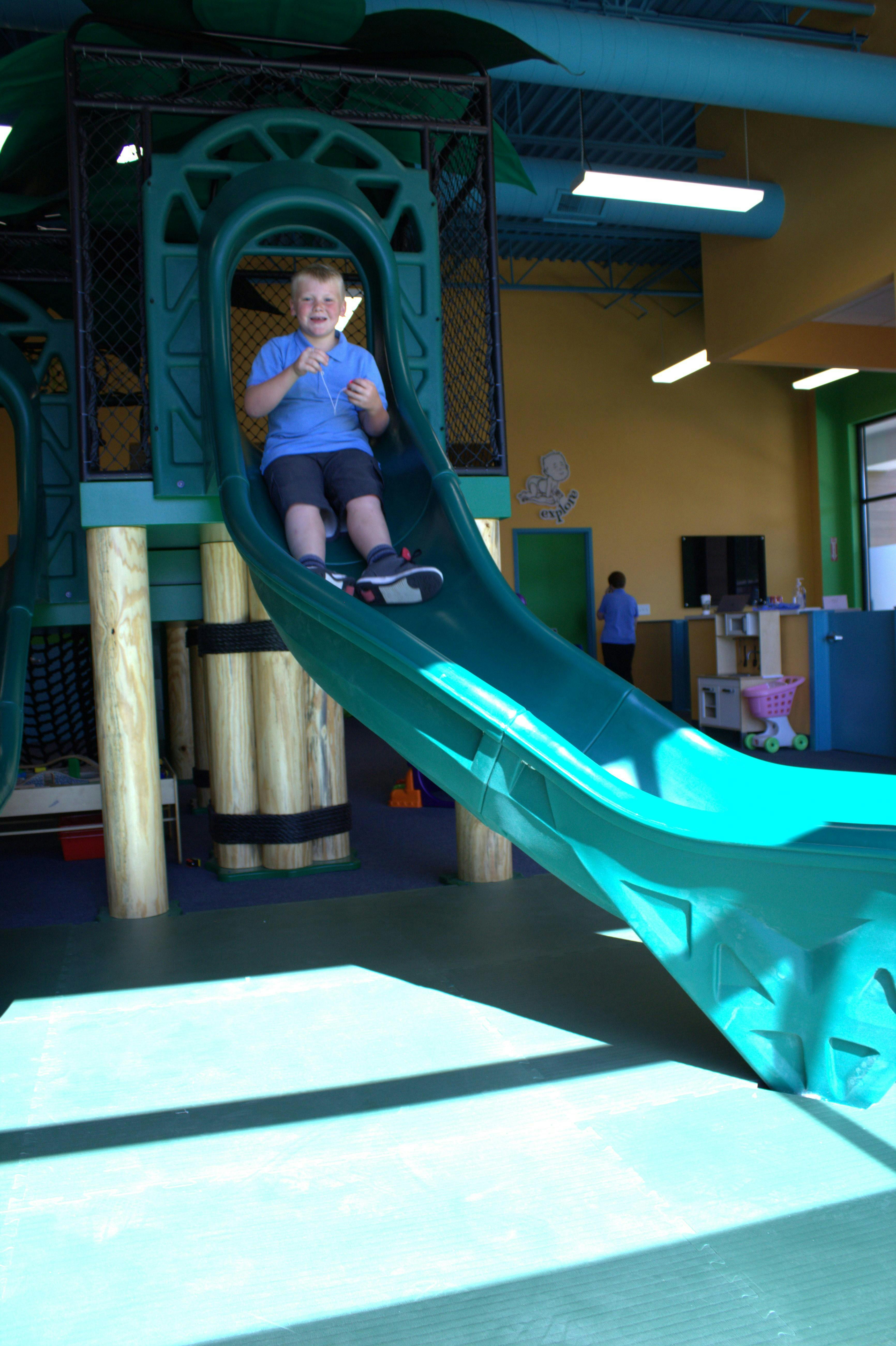 Child on a green playground slide